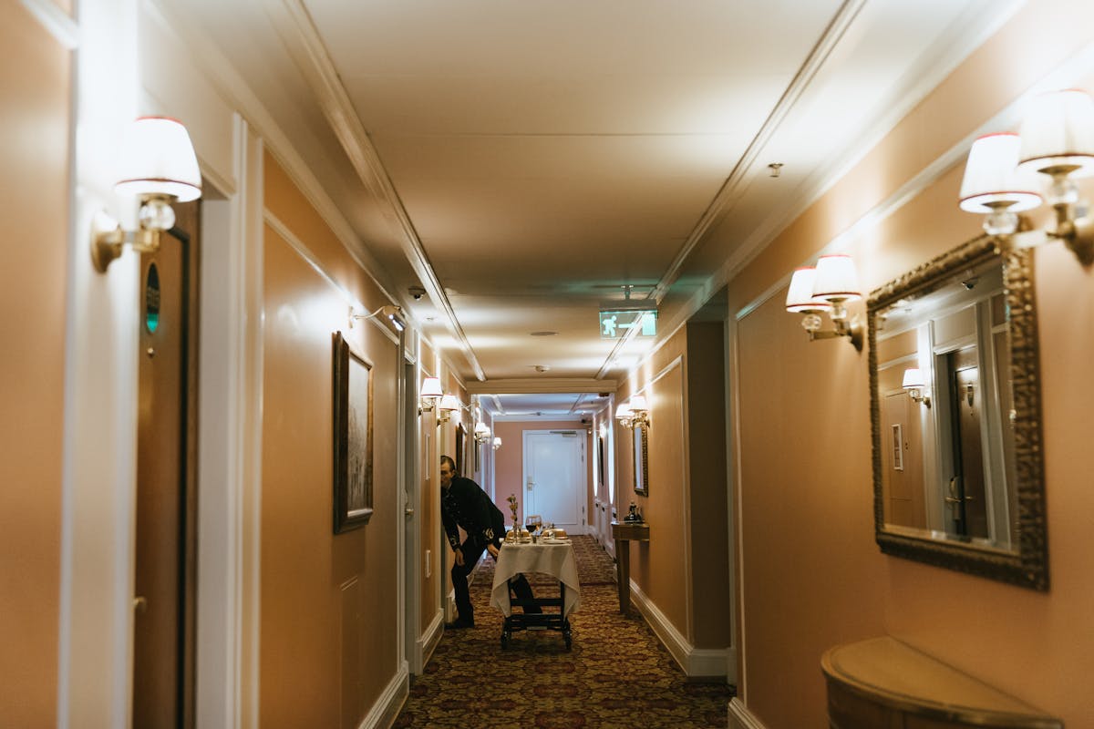 Hotel staff member with service trolley delivering luggage in elegant hotel hallway Japan