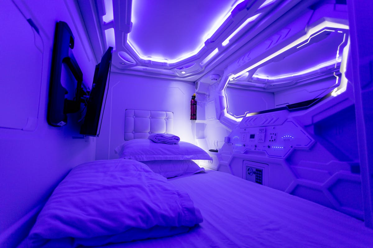 Futuristic capsule hotel room with ultraviolet purple lighting interior in Japan