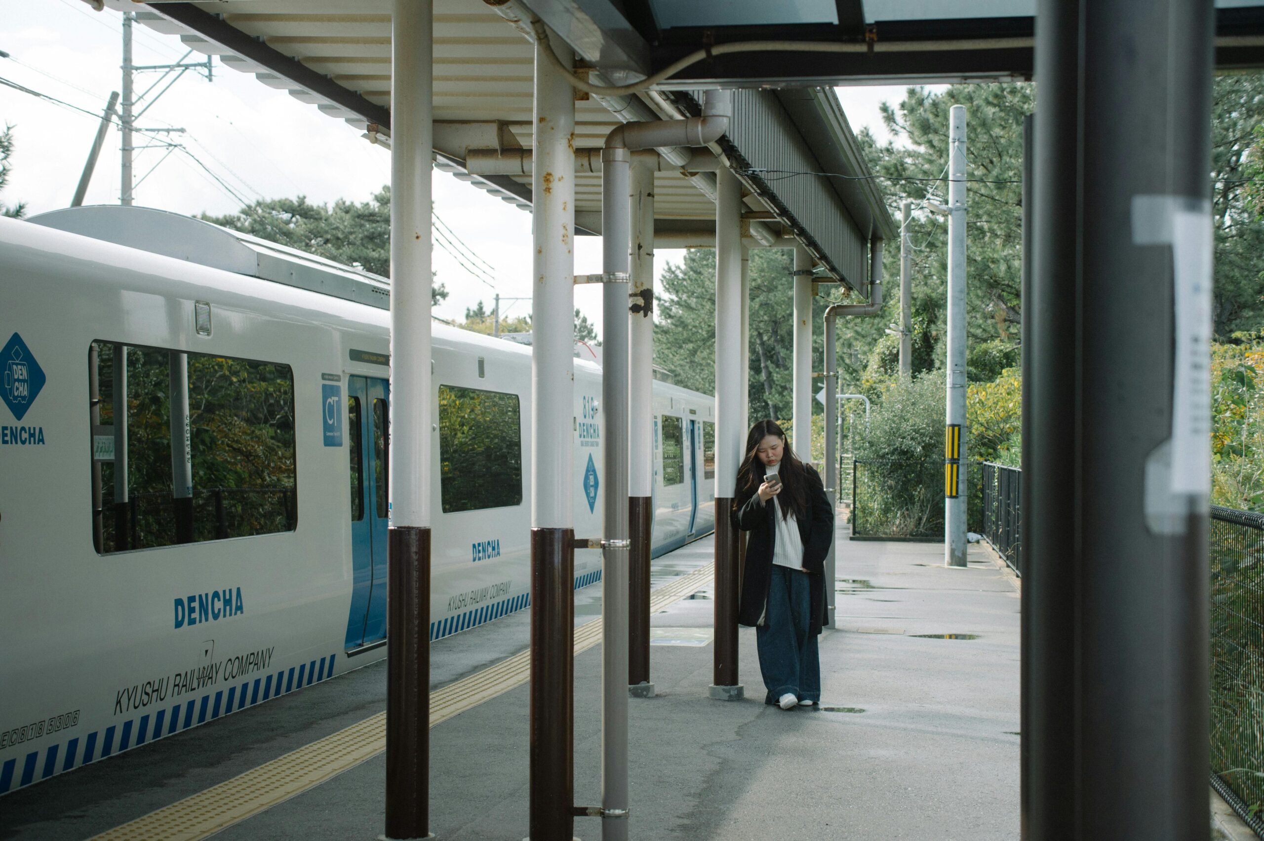 Traveller checking phone at a Japanese train station