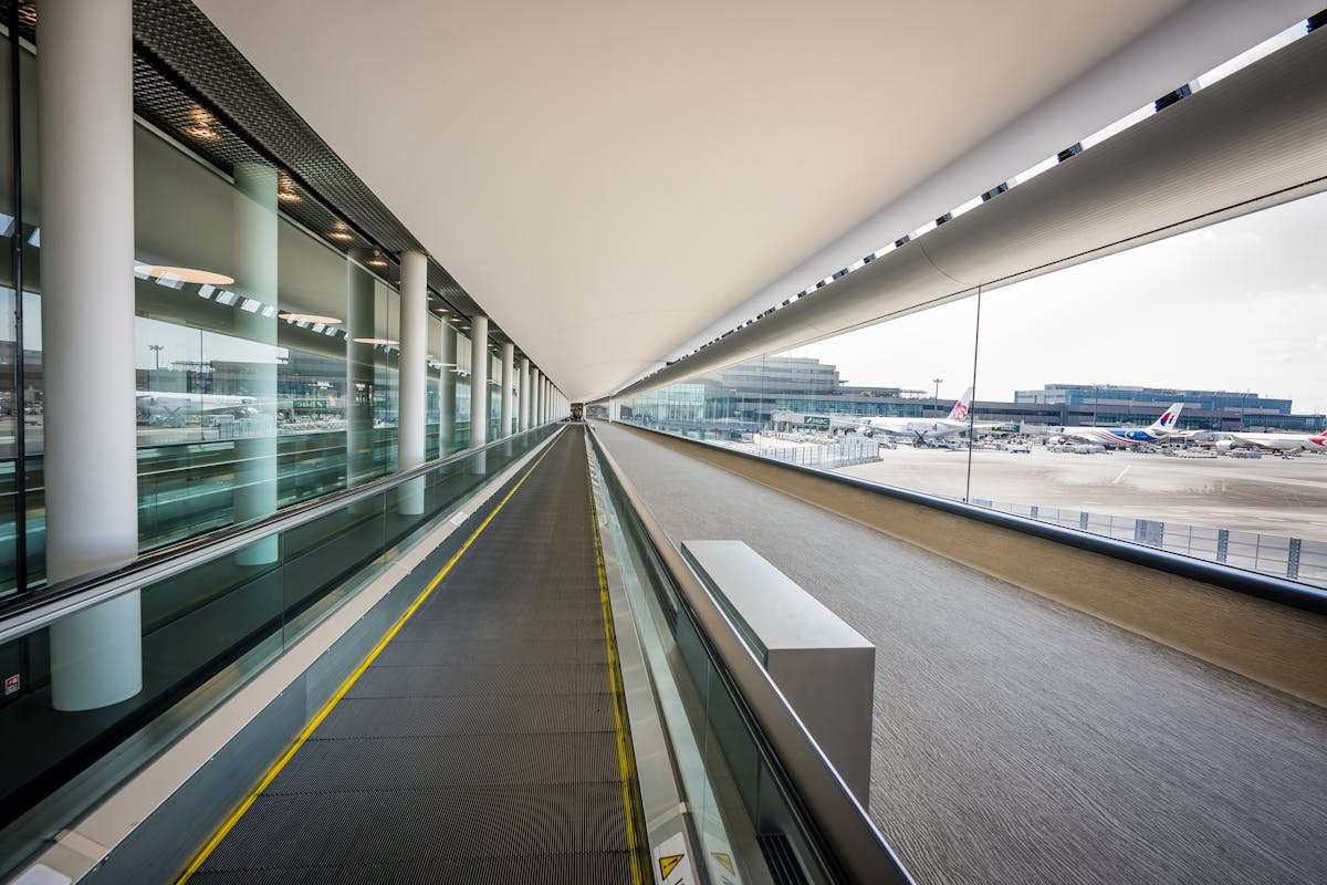 Sleek interior of Japanese airport terminal with moving walkway and aircraft visible outside