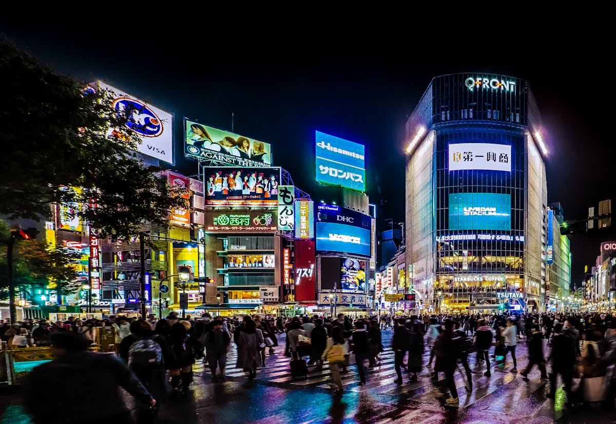 Shibuya Crossing Tokyo at night with crowds and neon lights