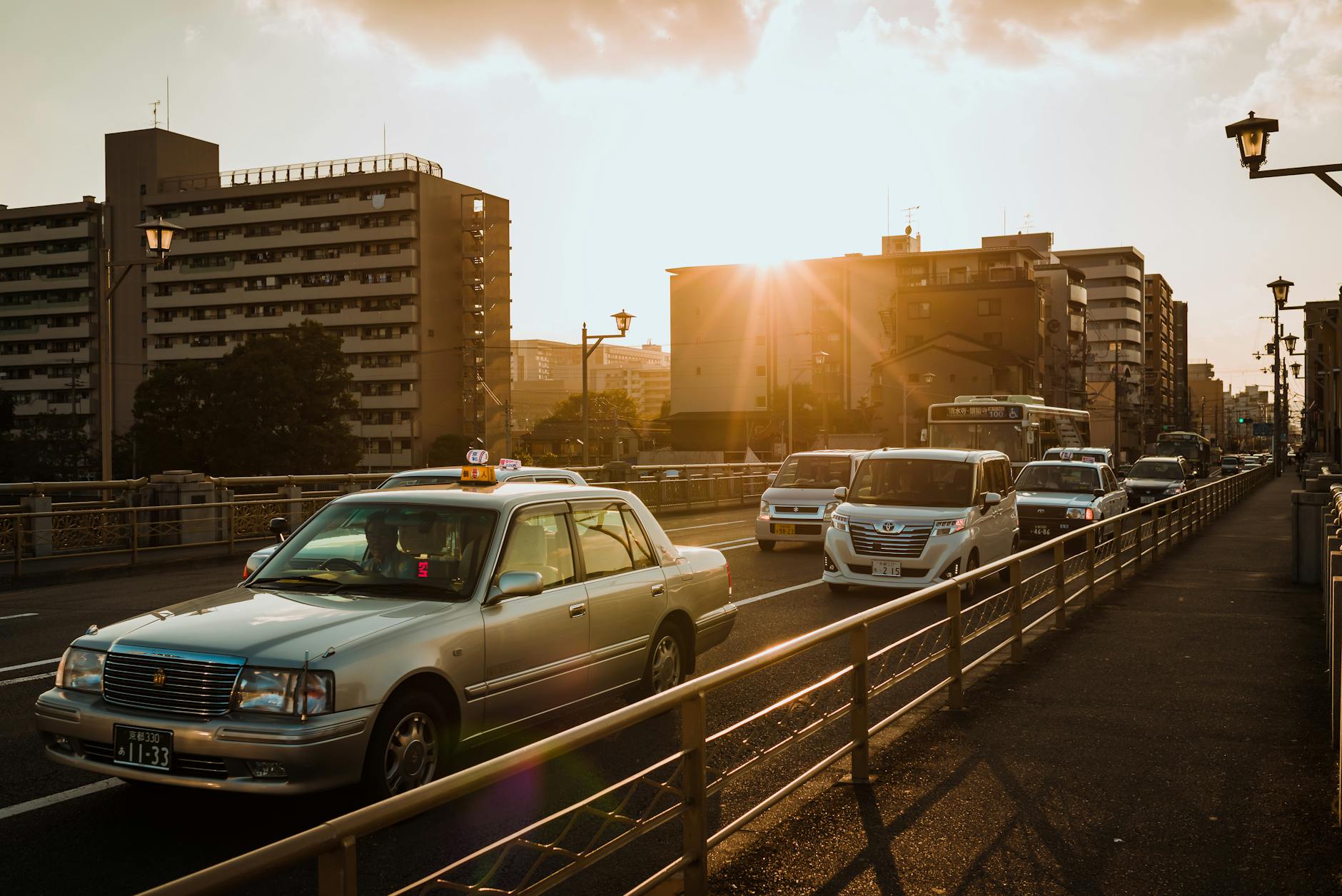 Vehicles driving on a road in Japan during a warm sunset, showcasing Japanese road and driving conditions