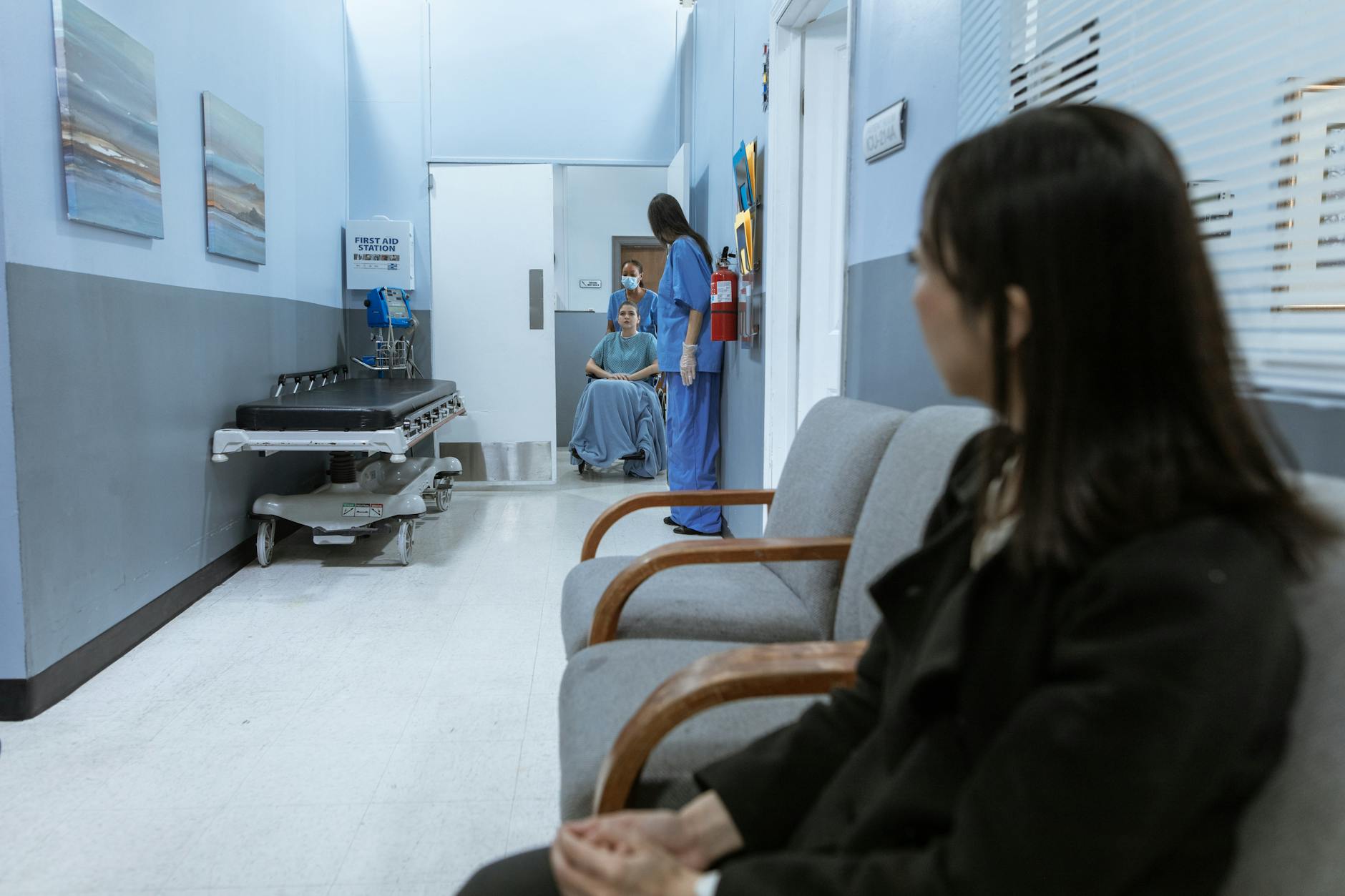 Hospital corridor with nurse assisting a patient in a wheelchair, representing healthcare and travel insurance in Japan
