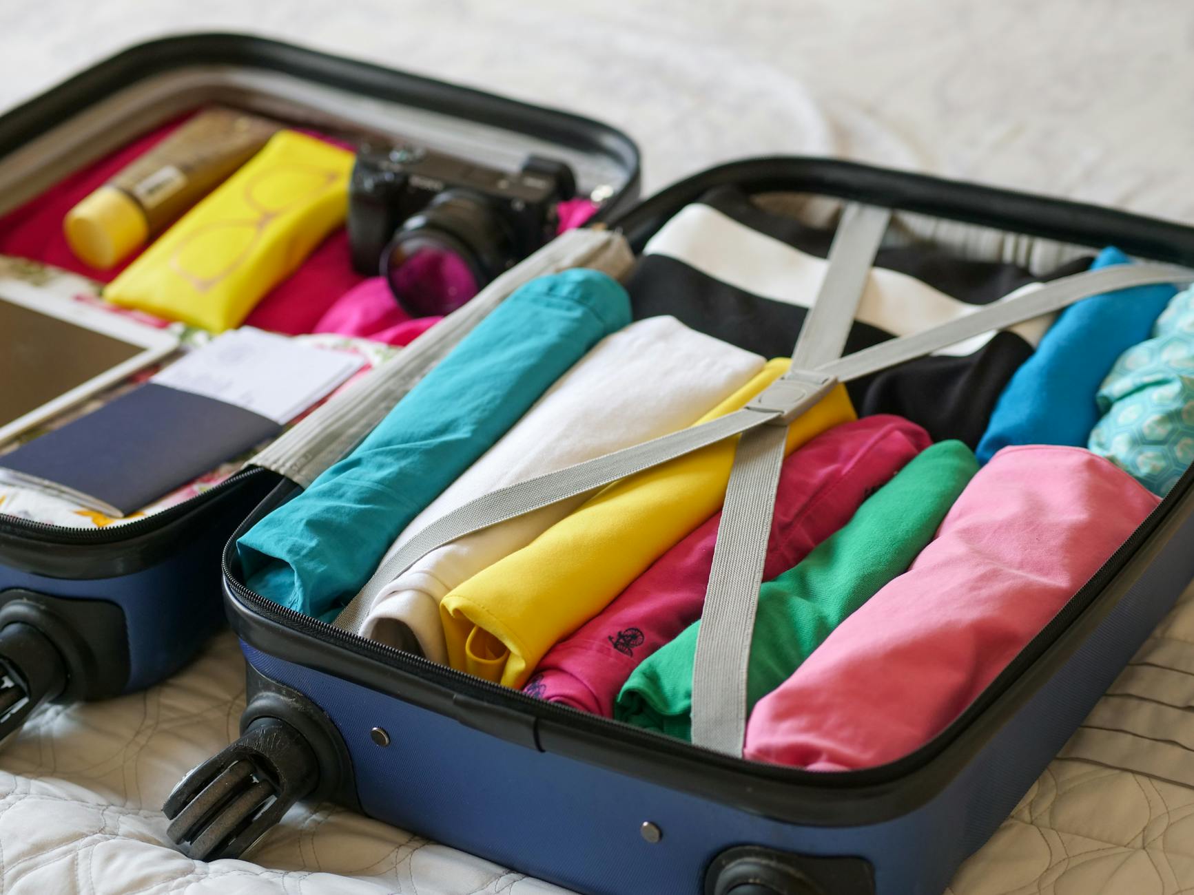 Open suitcase neatly packed with colorful clothes and travel essentials ready for a trip